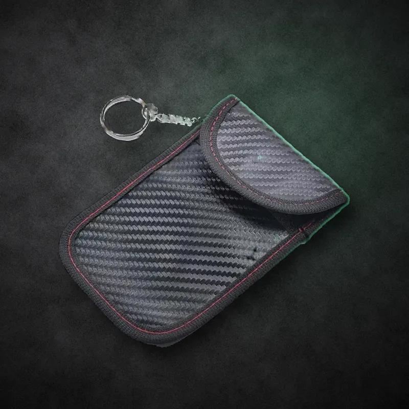 Pochette anti-relais noire effet carbone, fermée par son rabat, avec anneau porte-clés